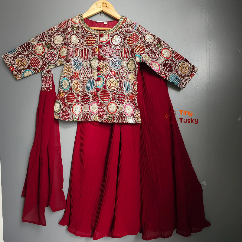 Traditional outfit with a patterned top and red skirt on a gray background
