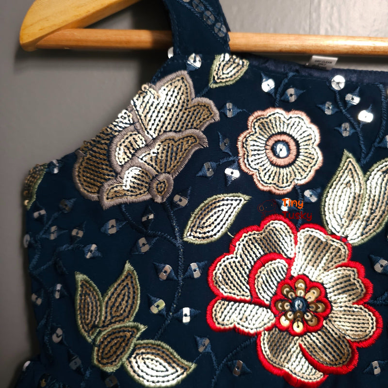 Embroidered fabric with floral patterns on a wooden hanger