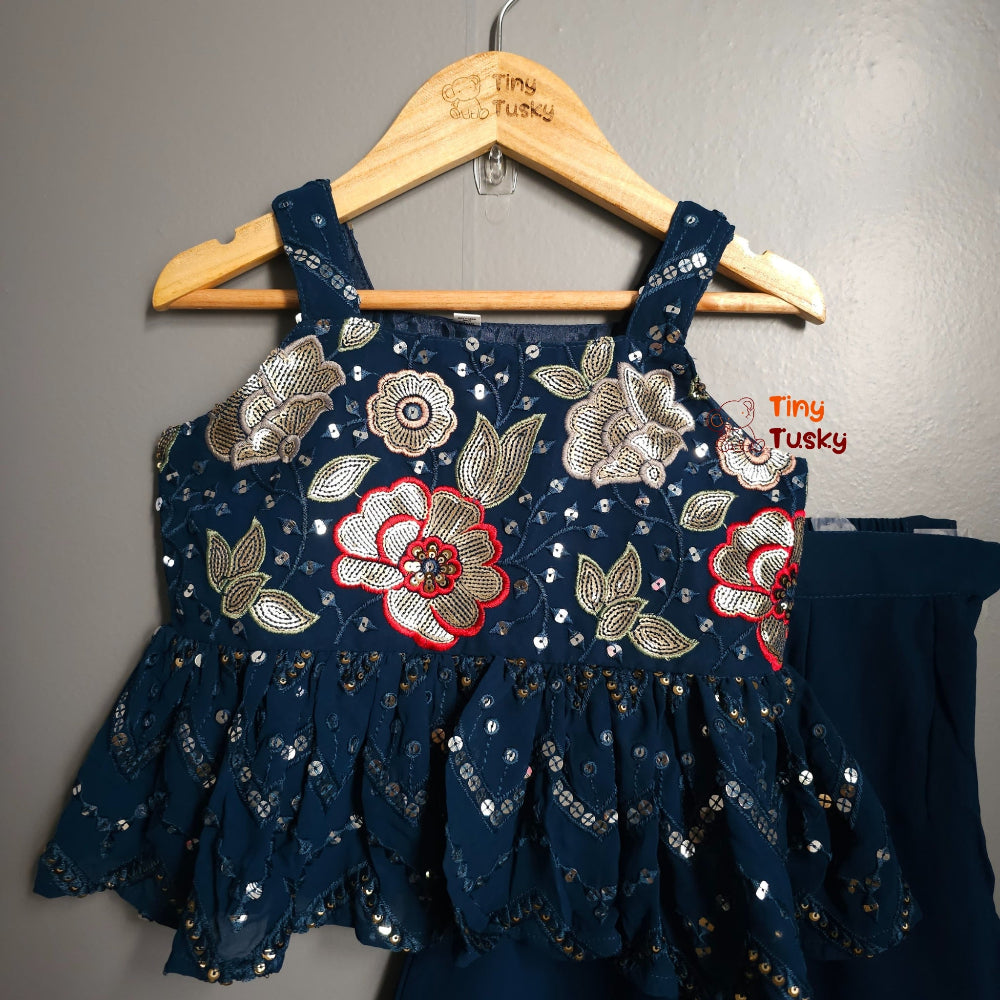 Navy blue embroidered dress on a hanger with 'Tiny Tusky' branding.