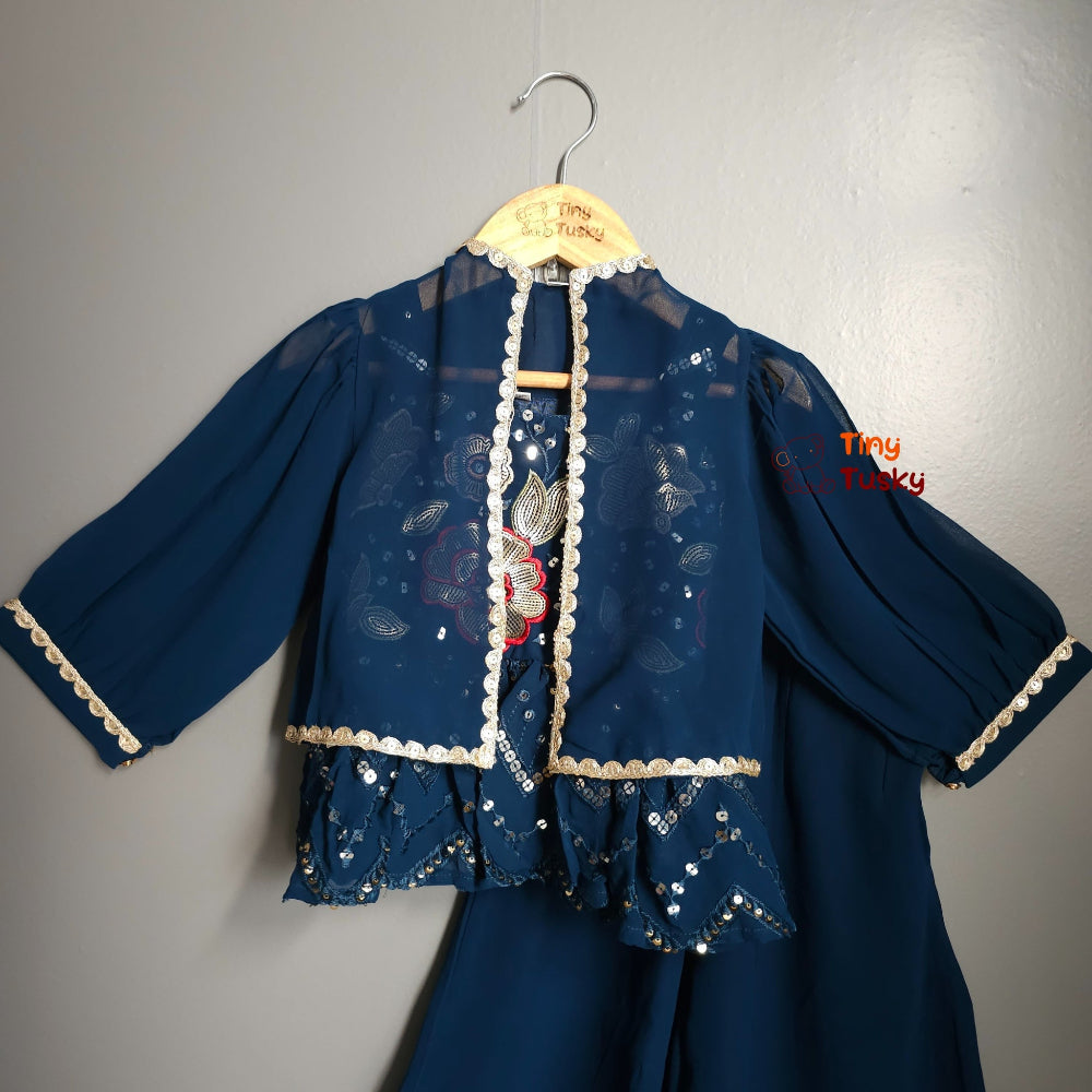 Blue embroidered outfit on a hanger against a gray background