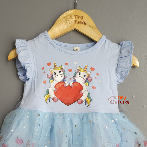Children's dress with unicorn design on a hanger, brand 'Tiny Tusky' visible